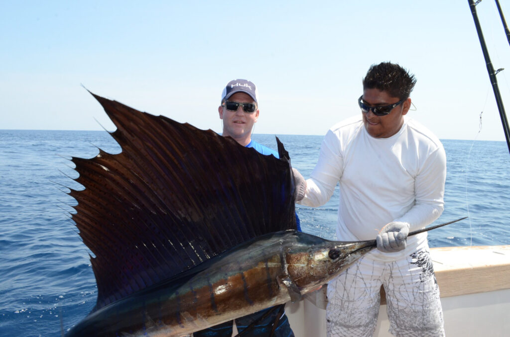 Anglers displaying a Pacific sailfish during a high-volume sailfish fishing trip in Costa Rica.